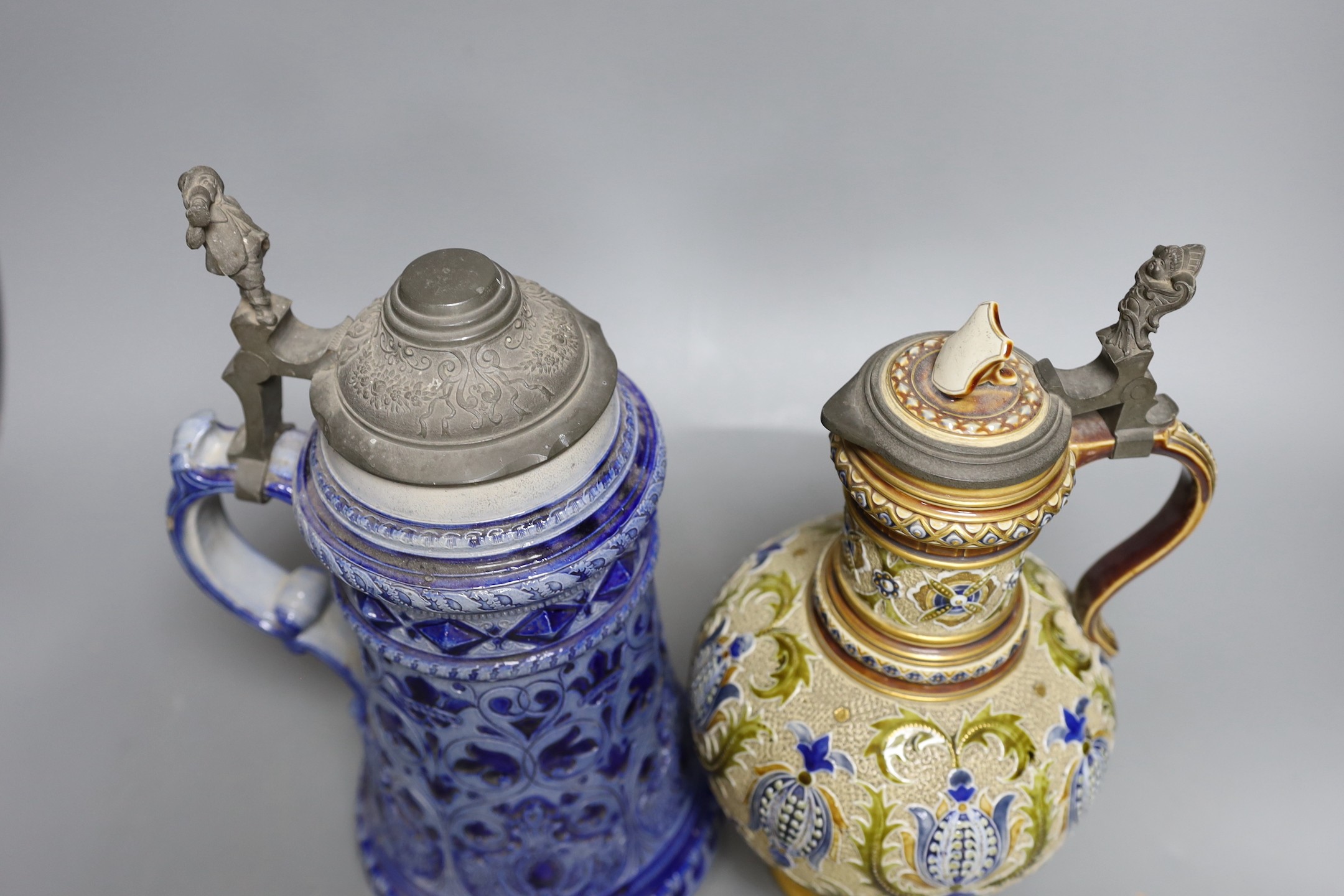 A Mettlach stoneware stein, 29.5 cm high, a German blue stoneware stein, a Staffordshire porcelain cottage pastille burner and an English porcelain floral plate